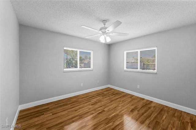 unfurnished room featuring ceiling fan, baseboards, a textured ceiling, and wood finished floors