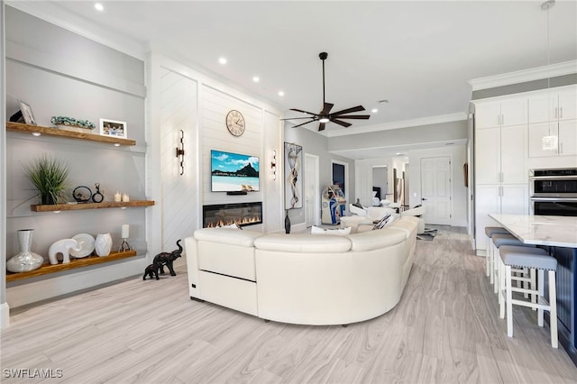 living room featuring ceiling fan, light wood-style flooring, ornamental molding, and recessed lighting