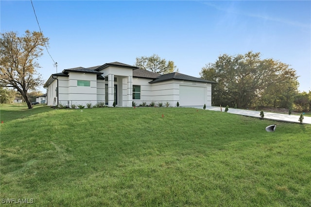 prairie-style house featuring a front yard, concrete driveway, and an attached garage