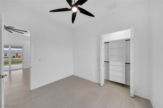 unfurnished bedroom featuring ceiling fan, a closet, baseboards, and light tile patterned flooring