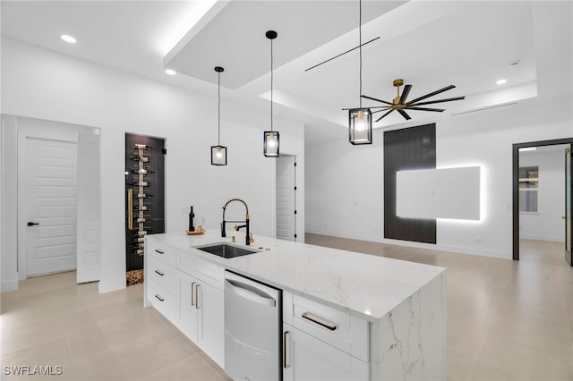 kitchen with open floor plan, dishwasher, a tray ceiling, and a sink