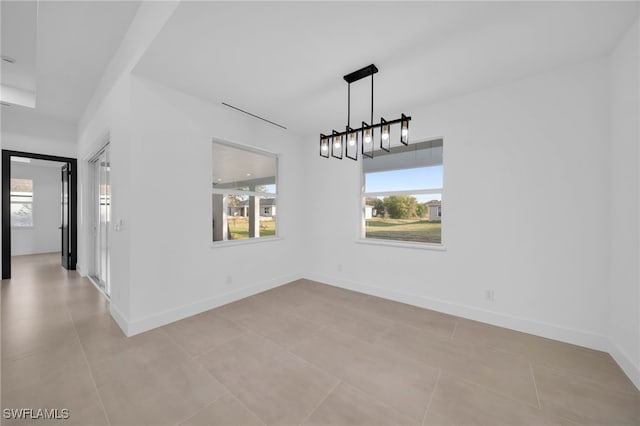 unfurnished dining area with light tile patterned floors and baseboards