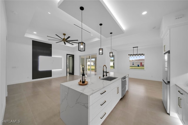 kitchen featuring a tray ceiling, recessed lighting, stainless steel appliances, and a sink