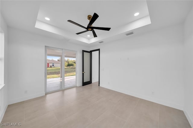 empty room featuring recessed lighting, baseboards, a raised ceiling, and ceiling fan