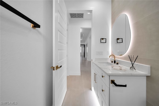 bathroom featuring tile patterned floors, visible vents, double vanity, and a sink