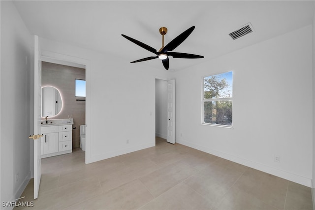 unfurnished bedroom featuring visible vents, a sink, ensuite bath, light tile patterned floors, and baseboards