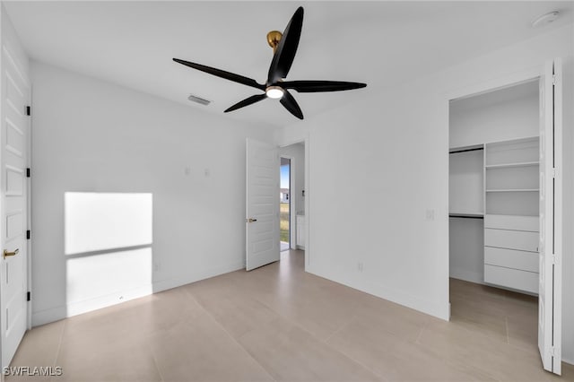 unfurnished bedroom featuring a spacious closet, a ceiling fan, visible vents, and baseboards