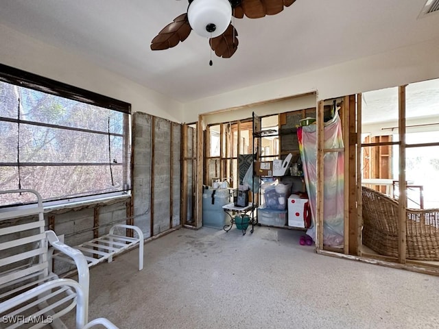 unfurnished sunroom featuring a wealth of natural light, visible vents, and ceiling fan