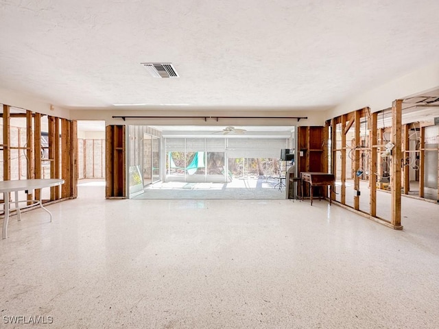 miscellaneous room with visible vents, speckled floor, and a textured ceiling