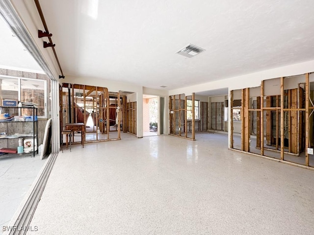 miscellaneous room featuring visible vents, a textured ceiling, and speckled floor