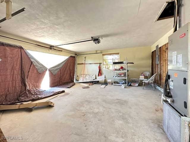 garage featuring heating unit and a garage door opener