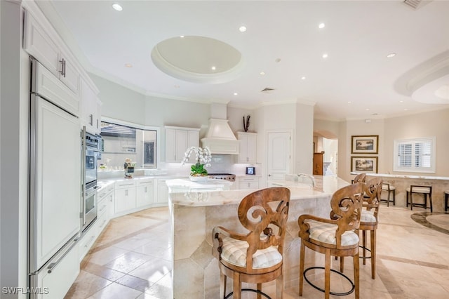 29115 W Teramo Way, Naples, FL 34110 - kitchen with premium range hood, recessed lighting, white cabinetry, and a large island with sink