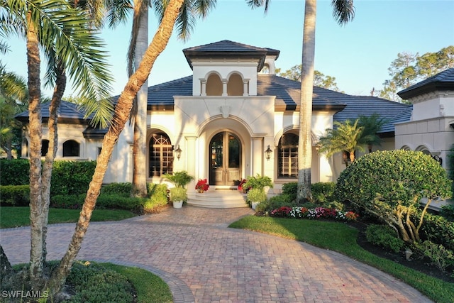 mediterranean / spanish home featuring french doors and stucco siding