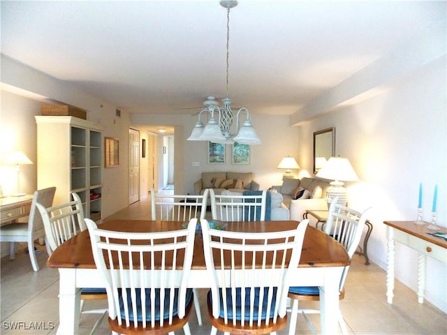 tiled dining space featuring a chandelier