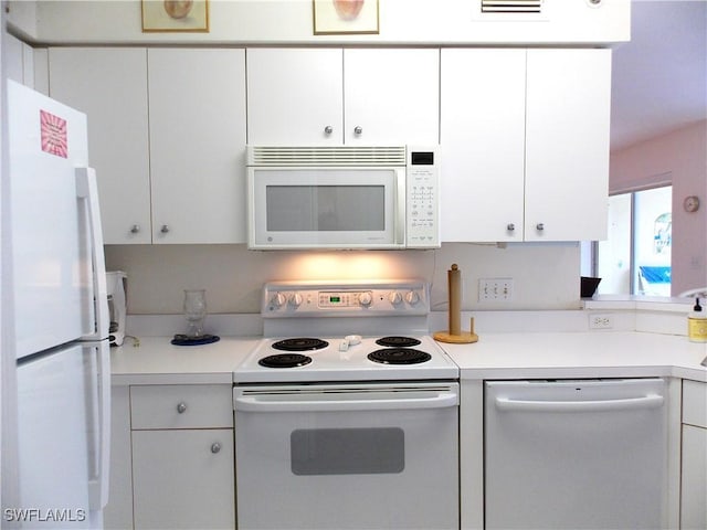 kitchen featuring white appliances, white cabinetry, and light countertops