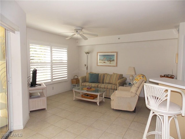 living area with light tile patterned floors and ceiling fan