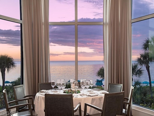 dining area with a wall of windows and a water view