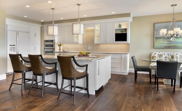 kitchen featuring decorative backsplash, double oven, dark wood-type flooring, and paneled refrigerator