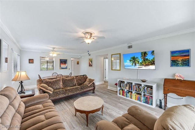 living room with wood finished floors, visible vents, baseboards, ceiling fan, and crown molding