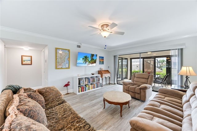 living room featuring visible vents, crown molding, baseboards, ceiling fan, and light wood-style flooring