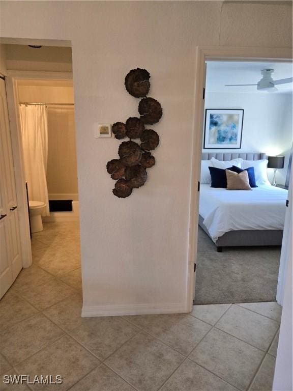 hallway featuring light tile patterned flooring and baseboards