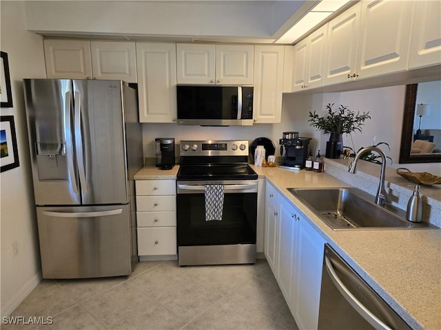 kitchen featuring light countertops, white cabinets, appliances with stainless steel finishes, and a sink