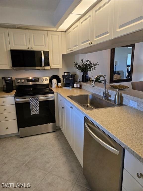 kitchen with a sink, light countertops, white cabinets, and stainless steel appliances