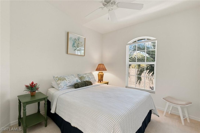 bedroom with light colored carpet, baseboards, and ceiling fan