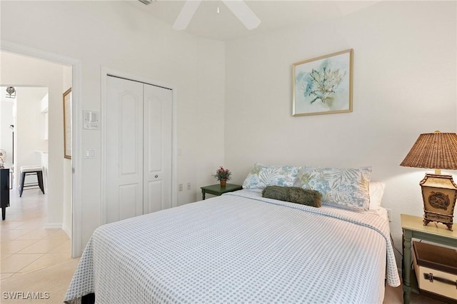 bedroom featuring a closet, light tile patterned floors, and ceiling fan