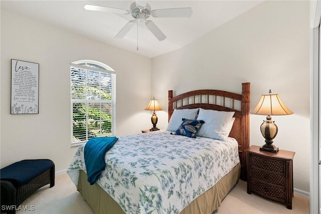 bedroom featuring light colored carpet, baseboards, and ceiling fan