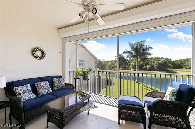 sunroom with ceiling fan and a water view