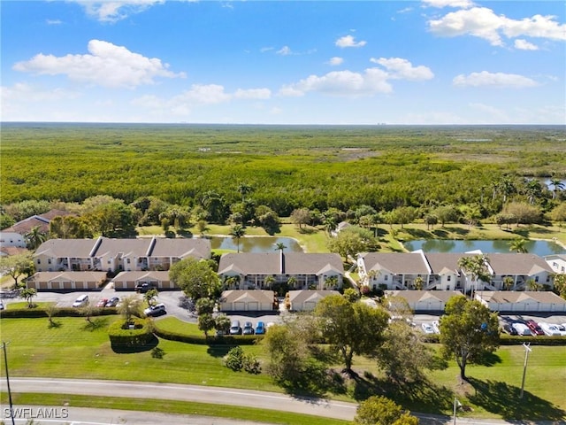 bird's eye view featuring a residential view, a wooded view, and a water view