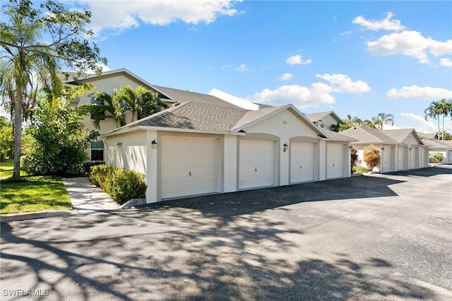 exterior space featuring stucco siding and roof with shingles