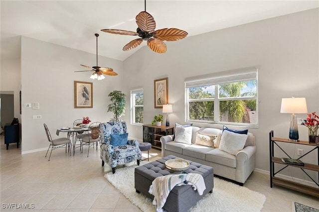 living room with ceiling fan, baseboards, and light tile patterned flooring