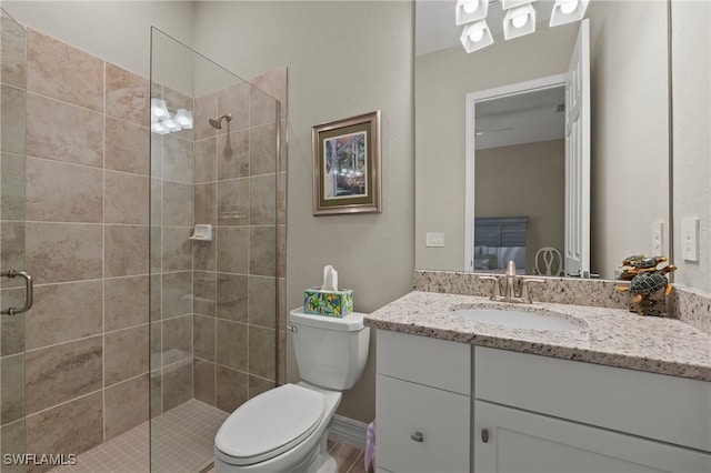 bathroom with vanity, a shower stall, and toilet