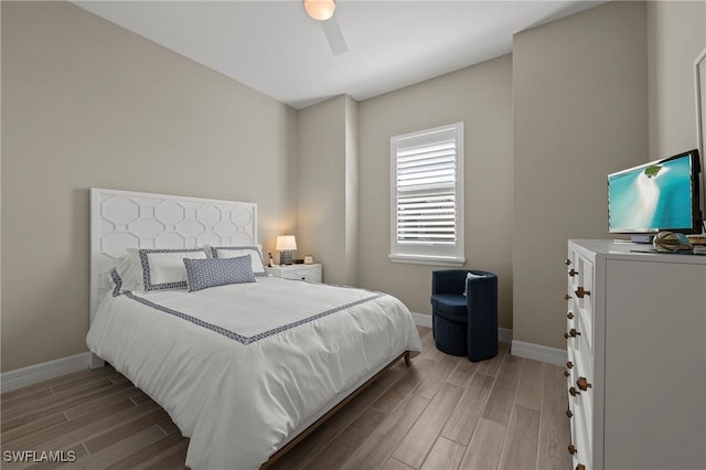 bedroom with baseboards, wood finish floors, and a ceiling fan