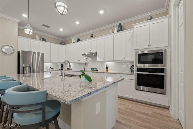 kitchen with crown molding, decorative backsplash, light wood-style flooring, appliances with stainless steel finishes, and a sink