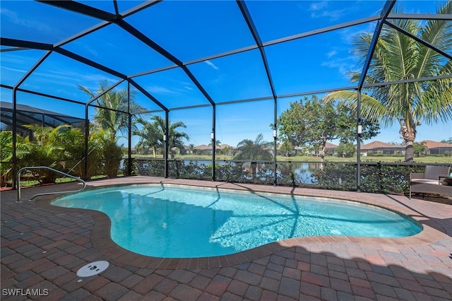 pool featuring glass enclosure, a patio, and a water view