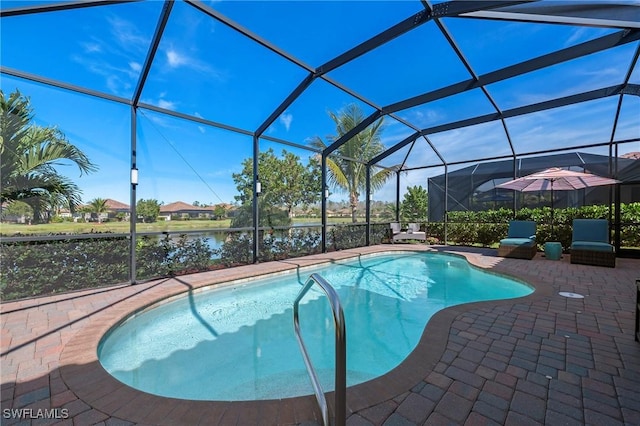 pool featuring glass enclosure, a patio area, and a water view