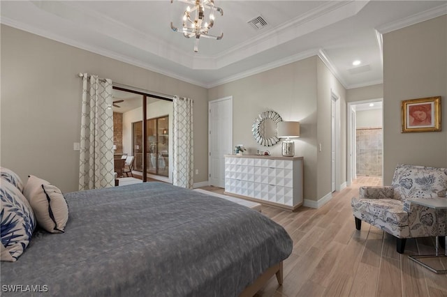 bedroom with wood finished floors, visible vents, baseboards, an inviting chandelier, and a raised ceiling