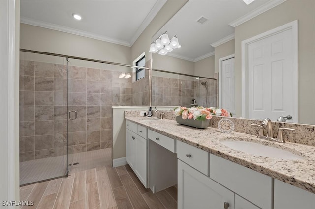 full bath featuring visible vents, a stall shower, a sink, crown molding, and wood tiled floor