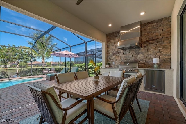 view of patio / terrace with a lanai, area for grilling, exterior kitchen, and outdoor dining space