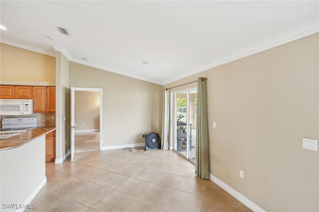 interior space featuring visible vents, ornamental molding, light tile patterned flooring, baseboards, and vaulted ceiling