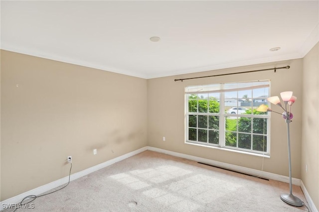 carpeted spare room featuring baseboards and ornamental molding