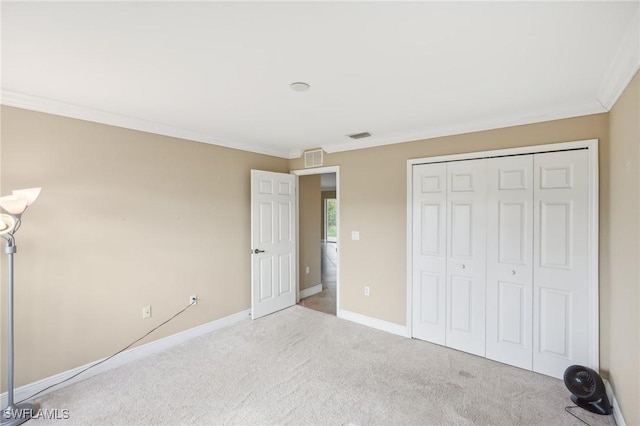 unfurnished bedroom featuring visible vents, ornamental molding, a closet, carpet, and baseboards