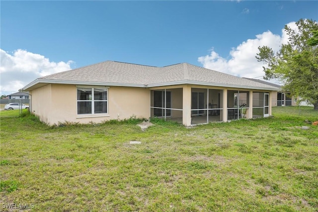 rear view of house featuring stucco siding, a lawn, roof with shingles, and a sunroom