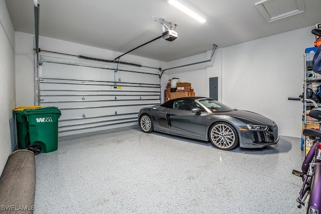 garage featuring electric panel and a garage door opener