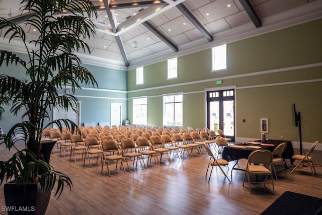 interior space with beam ceiling, plenty of natural light, and wood finished floors