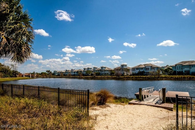 property view of water with fence, a residential view, and a boat dock