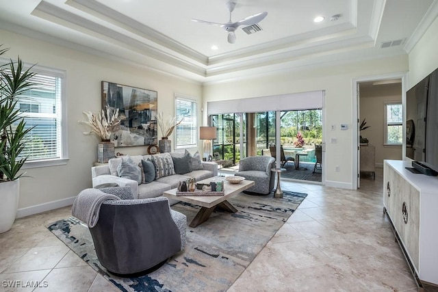 living room featuring a tray ceiling, visible vents, and a wealth of natural light